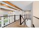 Open hallway showcasing wood beams, natural light, and elegant banister at 12598 Coastal Pl, Fishers, IN 46037