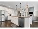 Open kitchen with island seating, stainless appliances, and open to living room with fireplace at 12598 Coastal Pl, Fishers, IN 46037
