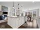Bright, modern kitchen featuring a spacious island, stone fireplace, and open concept design at 12598 Coastal Pl, Fishers, IN 46037