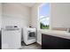 Practical laundry room featuring a washer, dryer, utility sink, and a view from a window at 12598 Coastal Pl, Fishers, IN 46037