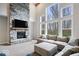 Sun-filled living room featuring a striking stone fireplace, and large windows showcasing the outdoor view at 12598 Coastal Pl, Fishers, IN 46037