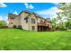 Exterior of a two-story brick home with a spacious backyard, inviting wooden deck, and green lawn at 13758 Foxdale Lake Dr, Carmel, IN 46032