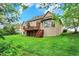 Expansive backyard view of a two-story brick home with a wooden deck and lush green lawn at 13758 Foxdale Lake Dr, Carmel, IN 46032