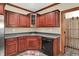Basement wet bar with stainless steel refrigerator and dishwasher and view into wine storage room at 13758 Foxdale Lake Dr, Carmel, IN 46032