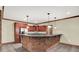 Entertaining basement space featuring a brick bar area, stainless steel fridge, and pendant lighting at 13758 Foxdale Lake Dr, Carmel, IN 46032