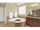 Bright bathroom features a soaking tub, vanity and neutral tile flooring at 13758 Foxdale Lake Dr, Carmel, IN 46032