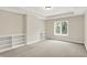 An empty room displaying neutral walls, built-in shelving, and a window with outside view at 13758 Foxdale Lake Dr, Carmel, IN 46032