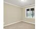 A simple bedroom with a single window and beige walls and carpet at 13758 Foxdale Lake Dr, Carmel, IN 46032