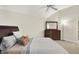 Comfortable bedroom featuring soft carpet, a ceiling fan, a bed with pillows, and a mirror on a dresser at 13758 Foxdale Lake Dr, Carmel, IN 46032