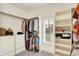 Walk-in closet with racks of clothing, built-in shelves, drawers, and natural light from the window at 13758 Foxdale Lake Dr, Carmel, IN 46032