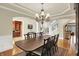 Elegant dining room featuring a chandelier, wood floors, and access to the office and staircase at 13758 Foxdale Lake Dr, Carmel, IN 46032