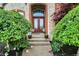 Inviting front entrance with double doors, decorative plants, and brick accents at 13758 Foxdale Lake Dr, Carmel, IN 46032
