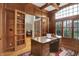 Elegant office featuring a large window, custom wood paneling and built-in bookshelves at 13758 Foxdale Lake Dr, Carmel, IN 46032