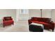 Bright and comfortable living room area with red furniture and neutral carpeting at 13758 Foxdale Lake Dr, Carmel, IN 46032
