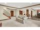 Open basement living room with exposed brick columns and staircase with wooden railings at 13758 Foxdale Lake Dr, Carmel, IN 46032
