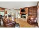 Inviting living room with brick fireplace, built-in shelving, and hardwood floors at 13758 Foxdale Lake Dr, Carmel, IN 46032