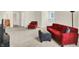 Large, naturally lit living room with red furniture and a glimpse into the kitchen at 13758 Foxdale Lake Dr, Carmel, IN 46032