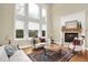 Bright living room features tall windows, a fireplace, and classic furniture, creating a sophisticated atmosphere at 13758 Foxdale Lake Dr, Carmel, IN 46032