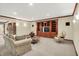 Spacious basement living area with built-in shelving, cozy seating, and modern lighting at 13758 Foxdale Lake Dr, Carmel, IN 46032