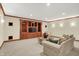 Inviting basement living room with custom built-ins and cozy seating, illuminated by recessed lighting at 13758 Foxdale Lake Dr, Carmel, IN 46032