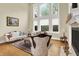 Elegant living room with fireplace, tall windows, and classic decor, ideal for relaxation and gatherings at 13758 Foxdale Lake Dr, Carmel, IN 46032