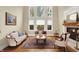 Bright living room with large windows, fireplace, and classic furniture creating a welcoming space at 13758 Foxdale Lake Dr, Carmel, IN 46032