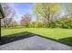 Expansive backyard with lush lawn, mature trees, and concrete patio perfect for entertaining at 138 Fairway Dr, Indianapolis, IN 46260