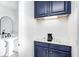 Modern bar area boasts blue cabinets, solid surface countertops, sink and coffee maker at 138 Fairway Dr, Indianapolis, IN 46260