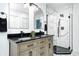 Modern bathroom features dual sink vanity, tiled walk-in shower with glass, and arched mirrors at 138 Fairway Dr, Indianapolis, IN 46260