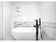 Spa-like bathroom featuring a modern freestanding soaking tub and black fixtures at 138 Fairway Dr, Indianapolis, IN 46260