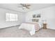 Bright bedroom with neutral carpet, ceiling fan, and large window with view of backyard at 138 Fairway Dr, Indianapolis, IN 46260
