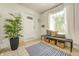 Inviting entryway with a white brick wall, a lush plant, and a large window at 138 Fairway Dr, Indianapolis, IN 46260