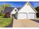 Charming home featuring a two-car garage, manicured lawn, and classic white siding under a blue sky at 138 Fairway Dr, Indianapolis, IN 46260