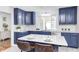 Bright kitchen features blue cabinets, white subway tile backsplash, and marble countertops and island at 138 Fairway Dr, Indianapolis, IN 46260