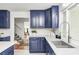 Bright kitchen features white subway tile backsplash and solid surface countertops, and blue cabinets at 138 Fairway Dr, Indianapolis, IN 46260