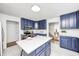 Spacious kitchen with stainless appliances, blue cabinets, island with chairs and seating for two at 138 Fairway Dr, Indianapolis, IN 46260