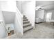 Carpeted stairway leading to a living area with natural light and a ceiling fan at 138 Fairway Dr, Indianapolis, IN 46260