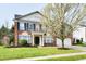 Charming two-story brick home featuring a well-manicured lawn and mature flowering tree at 13858 Meadow Lake Dr, Fishers, IN 46038