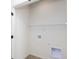 Bright laundry room with white walls, wooden baseboards, and a rack for storage at 14551 Hanford Ln, Carmel, IN 46074