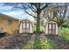 Backyard with two sheds, perfect for storage, alongside a well-maintained lawn and mature trees at 1457 Biloxi Ln, Beech Grove, IN 46107