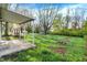 Expansive backyard featuring a covered patio, shed, and mature trees providing ample shade at 1457 Biloxi Ln, Beech Grove, IN 46107