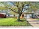 Charming single-story home featuring a well-maintained lawn, brick accents, and a lovely front yard tree at 1457 Biloxi Ln, Beech Grove, IN 46107