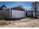 Image features a detached one car garage with a white door, complementing the residence at 1626 S Delaware St, Indianapolis, IN 46225