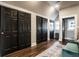 Well-lit hallway with stylish black doors, hardwood floors, and access to living spaces at 1626 S Delaware St, Indianapolis, IN 46225