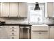 Close-up of the updated kitchen featuring white cabinetry, modern appliances, and a window over the sink at 1626 S Delaware St, Indianapolis, IN 46225