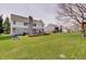 Large backyard features a wooden deck, tall tree, and neatly mowed lawn at 16994 Folly Brook Rd, Noblesville, IN 46060