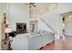 Bright living room featuring a staircase, fire place and sectional couch at 16994 Folly Brook Rd, Noblesville, IN 46060