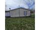 Exterior view of the home showing vinyl siding and boarded up window at 1704 E Kirk St, Muncie, IN 47303
