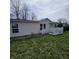 Modest single-story home with a small porch and vinyl siding at 1704 E Kirk St, Muncie, IN 47303