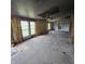Incomplete living room restoration with exposed insulation and three windows at 1704 E Kirk St, Muncie, IN 47303